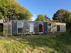 a small house in the middle of a field at Turismo Los Carbooneros de Pugueñun in Ancud