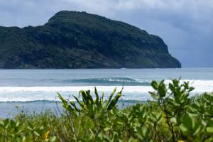 a view of the ocean with a mountain in the background at Irama Surf Villas - Private Pool Villas at Yoyos in Sekongkang