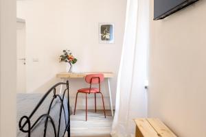 Affittacamere Work & Stay في فِتيربو: طاولة صغيرة في غرفة مع كرسي أحمر +25 صورة