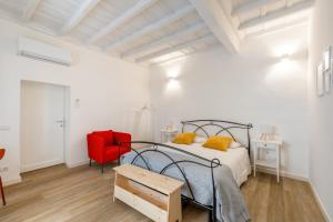 Affittacamere Work & Stay في فِتيربو: غرفة نوم بها سرير وكرسي أحمر