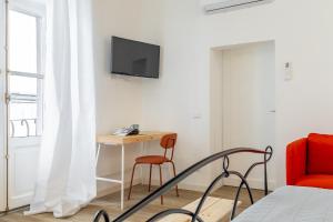 Affittacamere Work & Stay في فِتيربو: غرفة نوم بها سرير ومكتب وتلفزيون