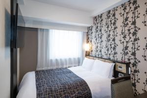 Una cama o camas en una habitación de APA Hotel Asakusa Tawaramachi Ekimae