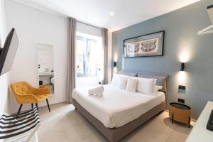 um quarto com uma cama e uma cadeira em um cômodo em Sardinian Days - Suites & Rooms em Cagliari mais 38 fotografias