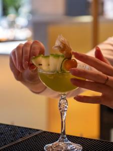 Una persona está preparando una bebida en una copa de vino. en Hyatt Centric Reims, en Reims