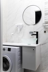 a bathroom with a washing machine and a mirror at Nowoczesny apartament GLAMOUR Łódź z prysznicem pośrodku in Łódź