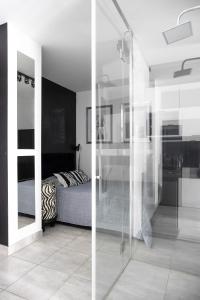 a room with a glass door leading to a bedroom at Nowoczesny apartament GLAMOUR Łódź z prysznicem pośrodku in Łódź