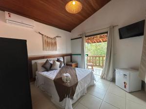 a bedroom with a bed with a table and a balcony at Pousada Mandalla in Serra do Cipo