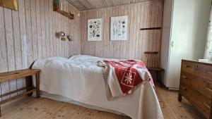 a bedroom with a bed and a wooden floor at Cozy cottage near Hälleviksstrand SE09132 in Hälleviksstrand