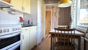 a kitchen with a stove and a table in it at Cozy cottage near Hälleviksstrand SE09132 in Hälleviksstrand +20 photos
