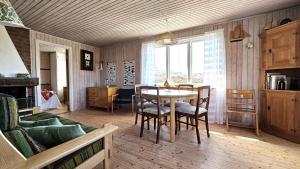 a living room with a table and chairs and a couch at Cozy cottage near Hälleviksstrand SE09132 in Hälleviksstrand