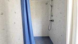 a shower with a blue curtain in a bathroom at Cozy cottage near Hälleviksstrand SE09132 in Hälleviksstrand