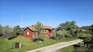 a red house on the side of a dirt road at Cozy cottage near Hälleviksstrand SE09132 in Hälleviksstrand