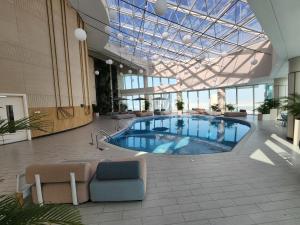 una gran piscina cubierta en un edificio con techo de cristal en Sea View Studio Perfect for Couples In Harbour Row, en Manama