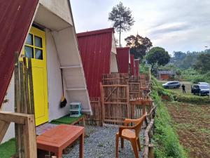 a house with a yellow door and a fence at Aubrey Villa Ciwidey in Pengalengan