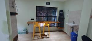 een badkamer met 2 stoelen, een tafel en een wastafel bij Umaa Sleeping Beds Dormitory in Pārvatīpuram +2 foto's