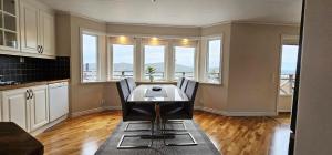 a dining room with a table and some windows at Modern villa with sea view in Svanesund SE09101 in Svanesund