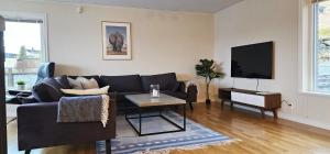 a living room with a black couch and a tv at Modern villa with sea view in Svanesund SE09101 in Svanesund