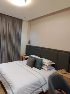 a bedroom with a large bed with pillows on it at Pazo by TLL in Ilorin