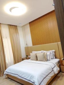 a bedroom with a large bed with white sheets and pillows at Pazo by TLL in Ilorin +1 photo