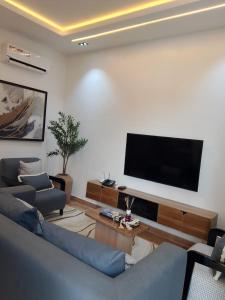 a living room with a blue couch and a flat screen tv at Pazo by TLL in Ilorin