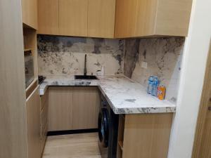 a small kitchen with a sink and a washer at Pazo by TLL in Ilorin