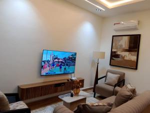 a living room with a flat screen tv on a wall at Pazo by TLL in Ilorin
