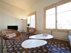 巴塞隆納的住宿－加泰羅尼亞廣場斯維茨福爾戴斯設計公寓，客厅配有2张桌子和椅子以及电视