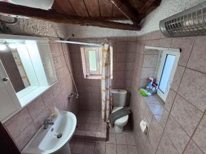 a bathroom with a sink and a toilet at Δωμάτια Εξοχή-With fireplace and view to the sea in Elíki +61 photos