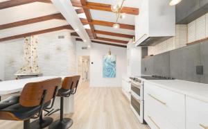 Una cocina con gabinetes blancos y una mesa y sillas. en Charming Four-Bedroom Coastal Retreat Near Neptune Beach, en Neptune Beach