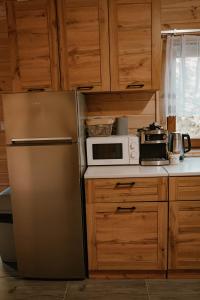 a kitchen with a refrigerator and a microwave at Sosnowy Domek Parter Zator Energylandia Graboszyce in Graboszyce +4 photos