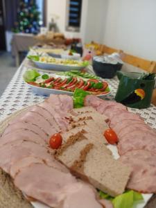 a long table with sandwiches and tomatoes on it at Pensjonat Magdalena - w cichym i spokojnym miejscu - zwierzęta akceptowane, bezpłatny parking in Szklarska Poręba