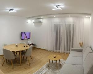 a living room with a table and a couch at Bella Vacanza Apartment in Banja Luka