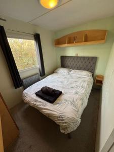a small bedroom with a bed with a pillow on it at The Lodge - 3BR, Woodland Forge, Garden Patio, Parking, Sleeps 6 in Over Whitacre