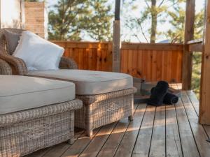 a patio with a chair and a ottoman on a deck at Barn Owl Cabin at Vrolikheid Landgoed in Tulbagh +8 photos