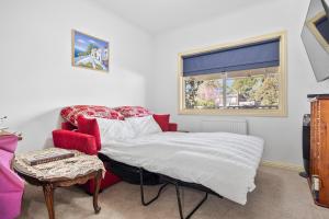 a bedroom with a bed and a red chair at Maureens Retreat in Eureka