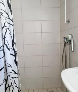 a bathroom with a shower curtain and a sink at Cozy cottage on beautiful Rossö, Orust SE09130 in Röd