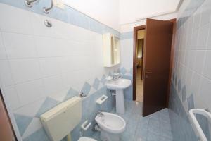 een blauwe en witte badkamer met een toilet en een wastafel bij Bright flat in Rosolina with shared pool in Rosolina Mare +19 foto's