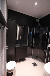 een zwarte badkamer met een wastafel en een douche bij Myrvoll 