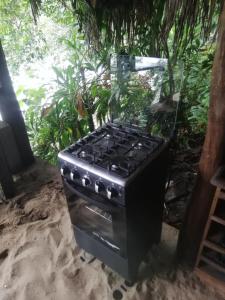 a stove top oven sitting in the sand at casa colibri cañón de rio dulce in Lívingston