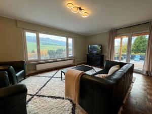 a living room with a couch and a tv at Eden Escapes in Olsberg