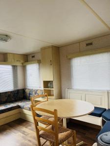 a room with a table and chairs and a couch at Camping de Zandput - ZP 340 in Vrouwenpolder