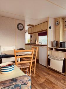 a kitchen and dining room with a table and chairs at Camping de Zandput - ZP 340 in Vrouwenpolder