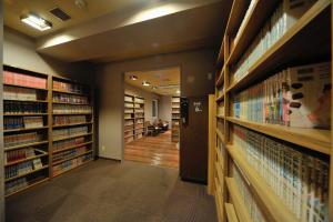 a library with many books on shelves and a hallway at Dormy Inn Express Koriyama in Koriyama