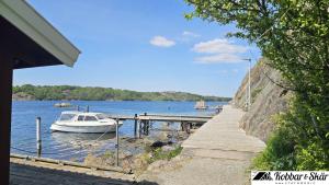 a boat is docked at a dock on a lake at Cottage with Private Shoreline in Boxvik SE09128 in Nösund