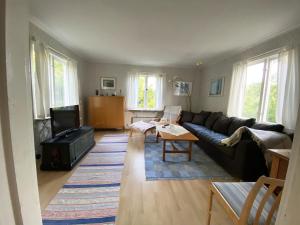 a living room with a couch and a tv at Cottage with Private Shoreline in Boxvik SE09128 in Nösund