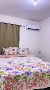 een slaapkamer met een bed met een bloemenbed bij Ap na Barra dos Coqueiros in Barra dos Coqueiros