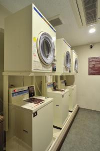 a laundry room with several washers and dryers on display at Dormy Inn Express Koriyama in Koriyama