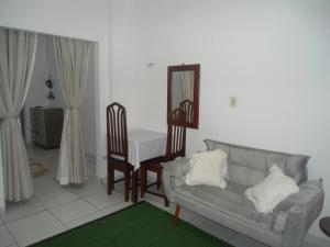 een woonkamer met een bank, een tafel en een spiegel bij Kit Net, No Centro Comercial de Belém in Belém