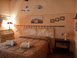 Agriturismo Il Maggio - Manciano في مانشانو: غرفة نوم بها سرير عليه منشفتان