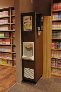 a library with a water dispenser in a book shelf at Dormy Inn Express Koriyama in Koriyama